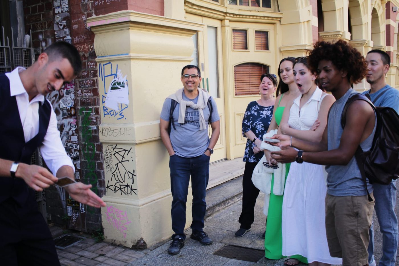 A street audience reacting to Dominic's magic